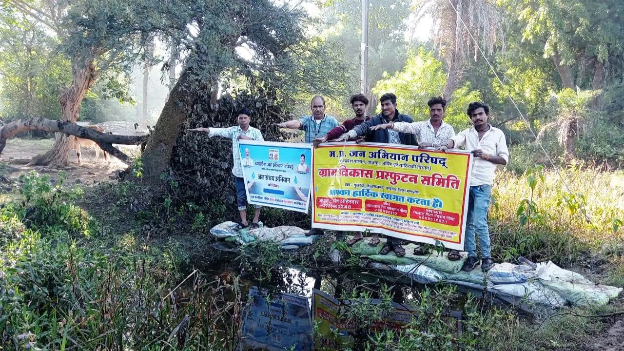 बोरी बंधान कर गुजरदा तालाब के निचले स्तर मे बह रहे पानी को रोका